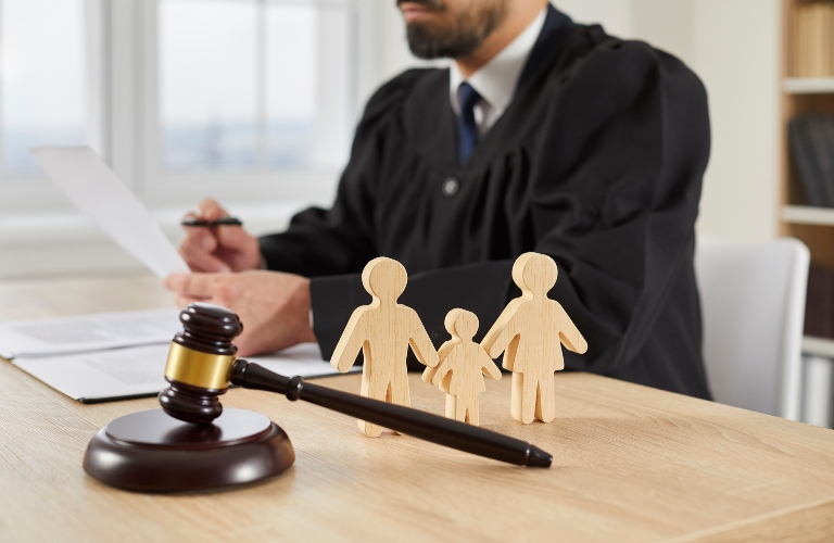 Gavel and little wooden figures of husband, wife and child