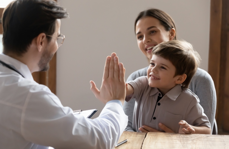 Happy little boy kid sitting on mommy's lap, giving high five to lawyer