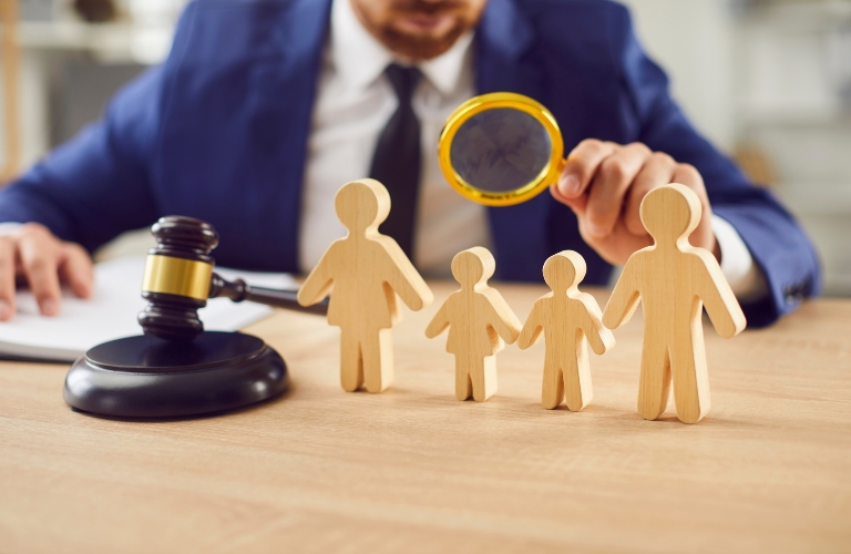 Judge examines wooden figures of a family in a courtroom